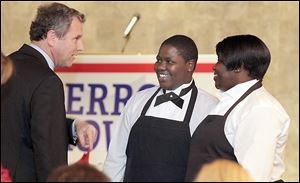 Sen. Sherrod Brown, left, introduces himself to dinner servers La'Mai Moore, center, and her mother, Melody Moore, both of Toledo, at the Lucas County Democratic Party's annual fall dinner.