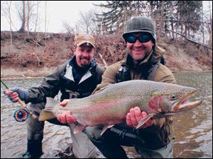 Kelly Gilmore of Mentor, Ohio, left, and Will Waldrip fo Austin, Texas, with a trophy steelhead caught on the Rockey River.