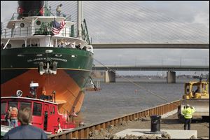 A bulldozer aids in the moving of the S.S. Col. James M. Schoonmaker into its new mooring in the shadow of the Veterans' Memorial Skyline Bridge.