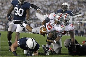 Ohio State quarterback Braxton Miller dives over Penn State linebacker Glenn Carson (40) for a third-quarter touchdown.