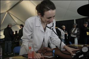 Mercy College fourth year nursing student Sydney Robinson takes blood pressure in the medical tent at Tent City.