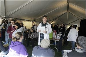 Nick Morse, a fourth year nursing student at Mercy College, calls for the next patient in the medical tent at Tent City.