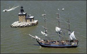 The HMS Bounty, visiting Toledo in 2003, is shown here passing the Toledo Harbor lighthouse during the Huntington Tall Ships Toledo festival. 