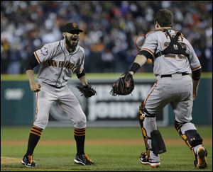 San Francisco Giants' Sergio Romo and catcher Buster Posey celebrate after the Giants defeated the Detroit Tigers, 4-3, in Game 4 of baseball's World Series Sunday.