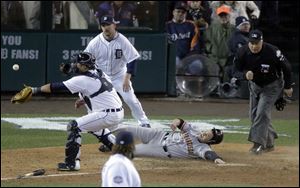San Francisco Giants second baseman Ryan Theriot slides safely to score a run past Detroit Tigers catcher Gerald Laird during the 10th inning of Game 4 of baseball's World Series against the Detroit Tigers Sunday.