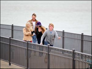 Amy and Randy Rozelle, battle the wind to make their way down the pier behind their daughter Brooke, 16, and Dylan, 14, during heavy winds at the shore in Luna Pier Monday. The Rozelle family, who are from North Redington Beach, Fla., escaped a family event to look at the coastline. 'Since we are native to that area [Florida] We are used to hurricanes!