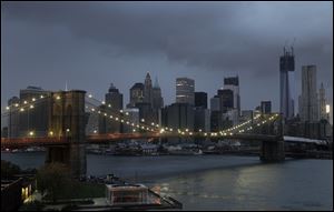 The lights on the Brooklyn Bridge stand in contrast to the lower Manhattan skyline which has lost its electrical supply after megastorm Sandy swept through New York.