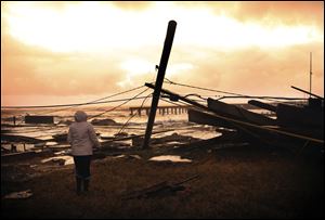 Kim Johnson looks over the destruction from superstorm Sandy near her seaside apartment in Atlantic City, N.J., today.