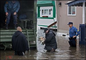 With the aid of New Jersey State police, a man walks with his dog to a National Guard vehicle after leaving his flooded home at the Metropolitan Trailer Park in Moonachie, N.J., Tuesday, in the wake of superstorm Sandy. 