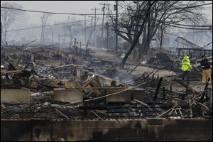 Officials assess the damage caused by a fire at Breezy Point in the New York City borough of Queens, Tuesday, where a fire destroyed between 80 and 100 homes.