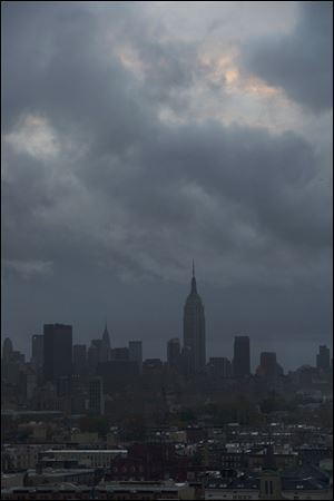 The Empire State Building and Midtown Manhattan are dark in this view from Jersey City, N.J., Tuesday morning after a powerful storm that started out as Hurricane Sandy made landfall on the East Coast.