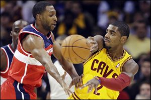 Cleveland Cavaliers' Kyrie Irving passes away from Washington Wizards' A.J. Price in the first quarter Tuesday, in Cleveland.