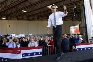 Republican presidential candidate, former Massachusetts Gov. Mitt Romney gives a thumbs up as he arrives at a campaign stop in Tampa, Fla., Wednesday. At rear on screen is a number for Red Cross donations for victims of superstorm Sandy.