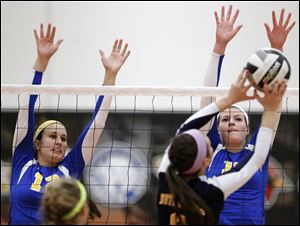 St. Ursula’s Lauren Daudelin, left, and Maddie Bunham defend against Notre Dame’s Morgan Loucks. Burnham leads the Arrows with 277 kills.