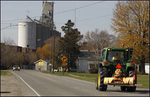 A tractor approaches Hicksville on State Rt. 18. This year, the drought hit the corn crop hard on some of the most fertile farmland in Ohio.