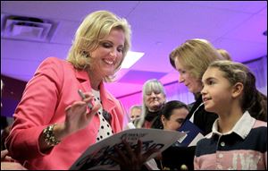 Ann Romney signs autographs after speaking at a victory rally for her husband and presidential candidate Mitt Romney on Thursday in Strongsville.