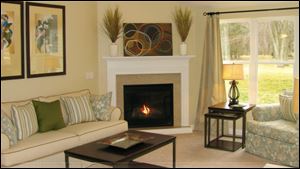 A vaulted ceiling and a gas fireplace with a granite surround make this great room an inviting space.
