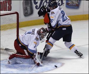 Toledo goalie Jordan Pearce stops a goal attempt by Ft. Wayne's Brett Smith with the help of Ben Youds during game against Ft. Wayne at the Huntington Center in Toledo, Ohio.  