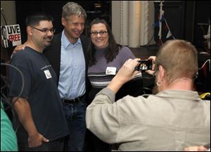 Joe and Angie Kolby, of Toledo, pose with Libertarian presidential candidate Gary Johnson, center, after his speech at the Clazel Theater in Bowling Green, Ohio.