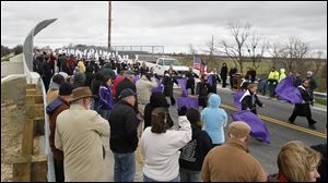 The Swanton High School Marching Band crosses the new Hallett Avenue overpass during a ceremonial grand opening. A train thundered under the bridge about the same time Friday. 