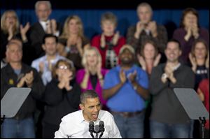 President Barack Obama speaks as supporters applaud behind him at a campaign event at Mentor High School on Saturday.