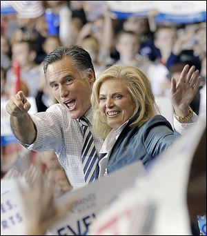 GOP presidential candidate Mitt Romney and his wife, Ann, greet about 6,000 in Cleveland. He outlined Sunday his first official acts should he win on Tuesday.