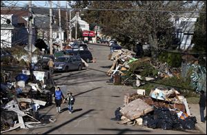 Garbage lies piled on the street in the New Dorp neighborhood of Staten Island, N.Y., on Sunday. FEMA says 182,000 individuals in Connecticut, New York, and New Jersey have registered for aid.