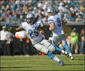 Detroit Lions running back Mikel Leshoure (25) runs for yardage after a handoff from quarterback Matthew Stafford (9) during the first half of an NFL football game against the Jacksonville Jaguars.