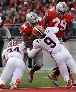 Ohio State running back Carlos Hyde (34) scores a touchdown as teammate Marcus Hall, right, tries to block Illinois defenders Mike Svetina, left, and Earnest Thomas. Hyde rushed for 139 yards and three TDs.
