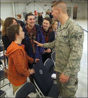 Toledoan Senior Airman Sean Fitzpatrick meets with his family after being honored during the Hometown Heroes Salute ceremony at the 180th Fighter Wing in Swanton.