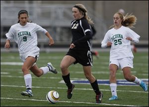 Perrysburg's Maddy Williams moves the ball against  Medina's Holly Rhodes (9) and Brianna Caccavale (25) during the Division II regional soccer final Saturday in Sandusky, Ohio.