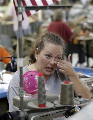 Apparel worker Misti Keeton wipes tears from her eyes as she talks about the possibility of losing her job to a convict, at American Power Source in Fayette, Ala.