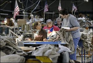 Apparel workers sew military uniforms at American Power Source in Fayette, Ala. American Power Source is laying off about 50 workers at the Fayette plant and another one in Columbus, Miss., after losing a contract to make Air Force exercise garb to Unicor. Many employees are worried that they will lose their jobs to convicts in the prison system. 