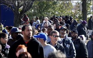 Loki Williams, 2, center, gets a seat on his dad's shoulders while waiting in a long line for early voting at the Early Voting Center in Summit Plaza.