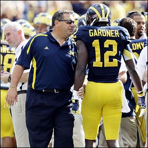 Michigan football coach Brady Hoke, left, hasn't experienced bad timing or bad karma during his time in Ann Arbor, unlike his predecessor, Rich Rodriguez.