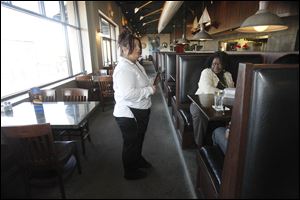 Lisa Schnabel, left, finishes up serving a table for customer Robin Reid, right, at the Admiral's American Grill.