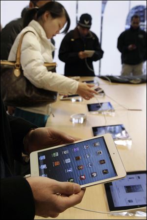 Shoppers check out the new Apple iPad mini at the Apple store on Michigan Ave. in Chicago. 