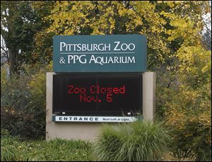 An electronic display sign near the entrance for the Pittsburgh Zoo and PPG Aquarium shows the zoo is closed on today in Pittsburgh. Zoo officials said a young boy was killed after he fell into the exhibit that was home to a pack of African painted dogs who pounced on the boy and mauled him on Sunday.
