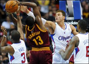 Los Angeles Clippers forward Blake Griffin (32) and guard Chris Paul (3) defend Cleveland Cavaliers forward Tristan Thompson (13) during the first half of an NBA basketball game in Los Angeles.