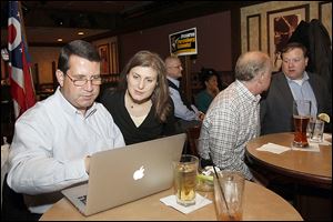 Matt Feasel, left, Perrysburg Schools' treasurer, and Rachel Johnson monitor election results during a Levy Watch Party at the Holiday Inn French Quarter in Perrysburg.