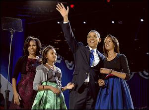 President Barack Obama waves as he walks on stage with first lady Michelle Obama and daughters Malia and Sasha at his election night party Wednesday, Nov. 7, 2012, in Chicago. Obama defeated Republican challenger former Massachusetts Gov. Mitt Romney. (AP Photo/Carolyn Kaster)