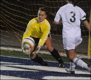 Perrysburg's Chloe Buehler makes a save on goal attempt as Strongsville's Melissa Shoff closes in during the second half.