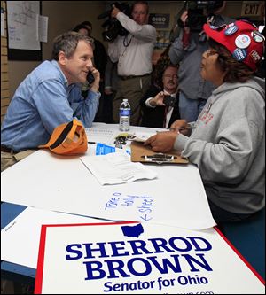 Sen. Sherrod Brown, along with volunteer Shirley Sherman, calls campaign workers on Tuesday to thank them for their service at a campaign office in Columbus.