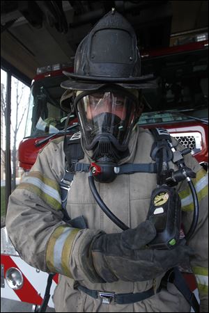 Jamie Morelock, a Toledo firefighter and paramedic, models the new breathing mask and control module. 