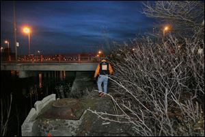 Bob Jones of Teen Street Outreach carries brown-bag lunches for runaways he may fi nd near a Maumee River bridge.