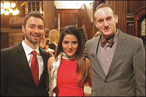 From left, Joshua Cooper, Negar Cooper, center, and Tim Hanson, right, pose for a photograph Friday evening during the Sapphire Blues to Benefit the Toledo Opera at the Toledo Club in Toledo. 