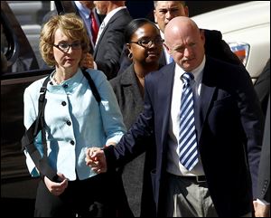 Former Democratic Rep. Gabrielle Giffords, left, and her husband Mark Kelly leave after the sentencing of Jared Loughner, in back of U.S. District Court Thursday in Tucson, Ariz. 