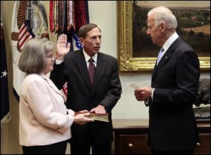 Holly Knowlton Petraeus holds the family bible as her husband David Petraeus is sworn in by Vice President Joe Biden as CIA Director, in the Roosevelt Room of the White House in Washington. Petraeus has resigned as director of the CIA after admitting he had an extramarital affair.