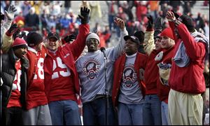 Cie Grant, center, sings Carmen Ohio with his old teammates.