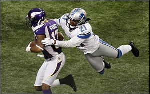 Minnesota Vikings wide receiver Jarius Wright, left, tries to break a tackle by Detroit Lions cornerback Jacob Lacey.